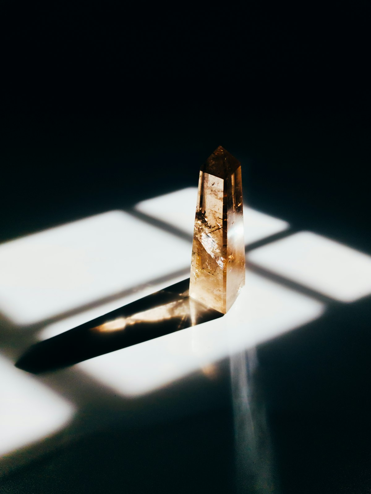 Smoky quartz crystal standing in a beam of window light