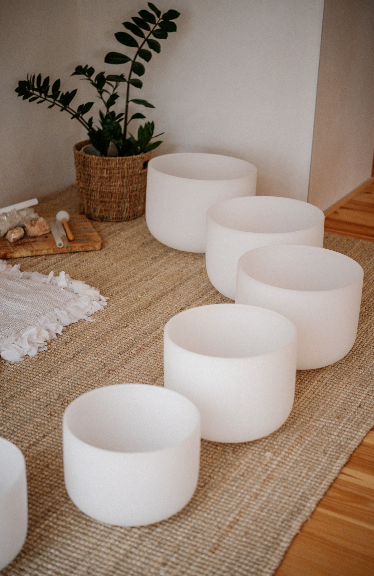 White crystal singing bowls on a woven rug